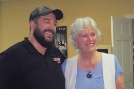 man and women standing in a room smiling
